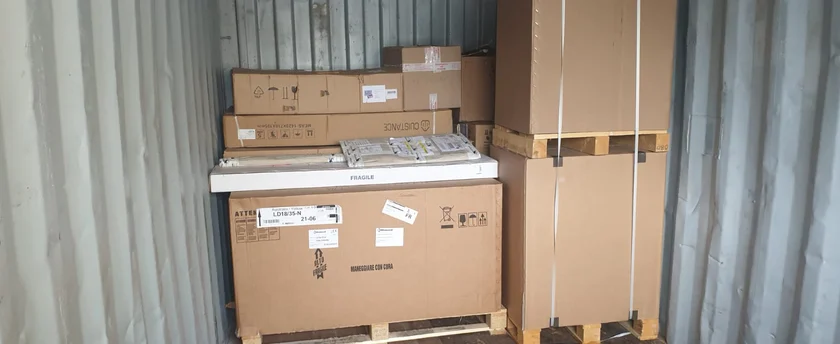 Cartons, palettes et colis sanglés dans un conteneur de groupage IFTL